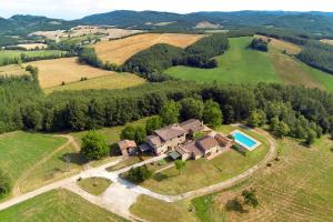 an aerial view of a house with a swimming pool on a field at Castellare in Chiusdino