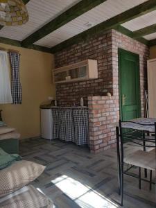 a kitchen with a brick wall and a green door at Bungalowy MARINA GREEN in Jarosławiec