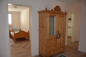a large wooden cabinet in a room with a bed at Moni's Ferienwohnung in Bad Bertrich