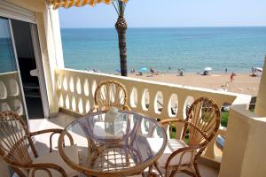 a table and chairs on a balcony with a view of the beach at Apartamentos Oliver Playa in Denia