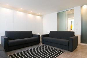 a living room with two black couches and a rug at Niclas Luxury Apartments in Rome