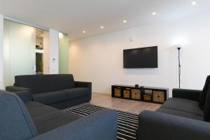 uma sala de estar com 2 sofás e uma televisão de ecrã plano em Niclas Luxury Apartments em Roma