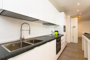 a kitchen with white cabinets and a sink at Niclas Luxury Apartments in Rome