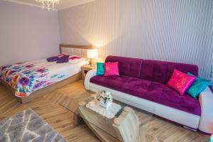 ザコパネにあるLuksusowy Apartament Bon Appetit -Centrum-Krupówki-Zakopaneの紫色のソファとベッド付きのリビングルーム