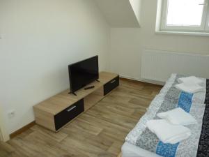 sala de estar con 2 camas y TV de pantalla plana en Apartmán Relax-chatka a apartmán, en Mikulov