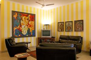 a living room with two couches and a tv at Colonel’s Retreat in New Delhi