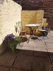a patio with a table and chairs and flowers at No7 Agar Street in York
