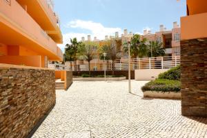 a courtyard of a building with palm trees and buildings at Franciscos em Cabanas Golf in Conceição