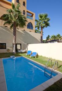 
a swimming pool with a tennis court in front of it at Apartamentos Playamarina in Isla Canela
