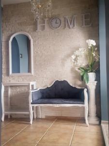 um quarto com um sofá azul e uma parede com um relógio em Pokoje u Camili em Rewa
