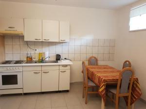 a kitchen with white cabinets and a table and a sink at ARTEMISFARM APARTMENT 3 in Bad Blumau