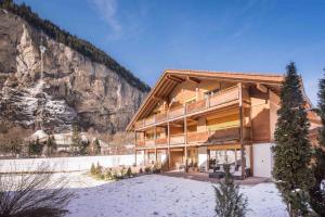 a large wooden building with a mountain in the background at Hafod a Hendre in Lauterbrunnen