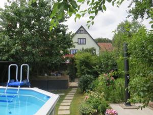 un patio trasero con piscina y una casa en Ferienwohnung "Waldblick" en Bad Liebenstein