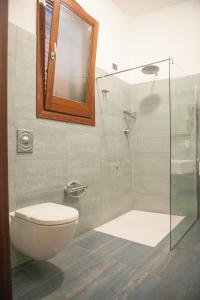 a bathroom with a toilet, sink, and shower at Hotel Il Portico in Favignana