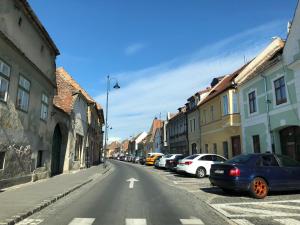 a street with cars parked on the side of the road at Folkloric Loft - Sibiul vechi in Sibiu