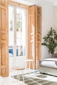 een slaapkamer met een bed en 2 krukken bij BNBHolder Group Stunning SOL in Madrid
