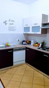 eine Küche mit weißen Geräten und Holzböden in der Unterkunft Apartments Kaić 1045 in Pula