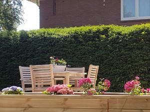 a table and chairs and flowers in front of a hedge at Excellent 21 in Soesterberg
