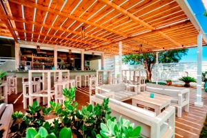 a patio with white chairs and tables and a bar at Naya in Kissamos