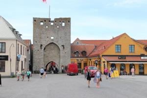een groep mensen die in een stad wandelen met een kasteel bij Alyhrs takvåning i Visby in Visby