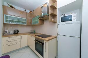 eine Küche mit weißen Geräten und einem weißen Kühlschrank in der Unterkunft Apartment "San Marino" in Baška Voda