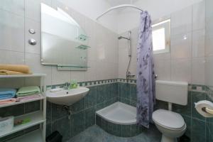 ein Badezimmer mit einem Waschbecken, einem WC und einem Spiegel in der Unterkunft Apartment "San Marino" in Baška Voda