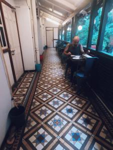 a man sitting at a table in a restaurant with a tiled floor at Carlton Hotel Mumbai - Behind Taj Mahal Palace Colaba Mumbai in Mumbai