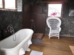 a bathroom with a white tub and a chair at Casa La Geria in La Asomada