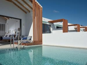 a house with a swimming pool next to a bedroom at Hotel St.John Suites Adults Only in Tsilivi