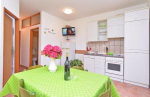 een keuken met een tafel met een vaas met bloemen erop bij Apartments Denis 344 in Fažana