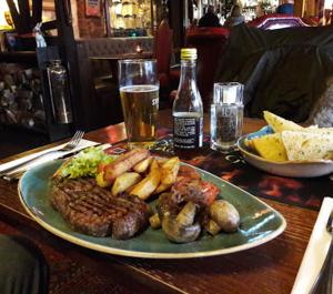 un plato de carne y setas en una mesa en The Swan Inn en Nantwich