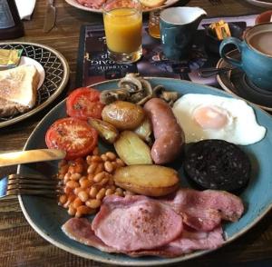 a blue plate of breakfast food on a table at The Swan Inn in Nantwich