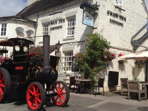 una vieja máquina de vapor estacionada frente a un edificio en The Swan Inn en Nantwich