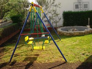 a playground with a slide in a yard at Apartments Marijan in Pirovac