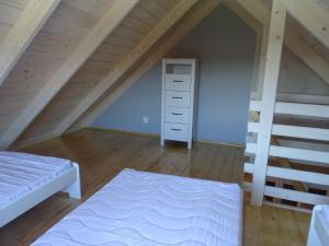 ルシノボにあるMORELOWE domki nad morzemの屋根裏のベッドルーム(ベッド2台、はしご付)