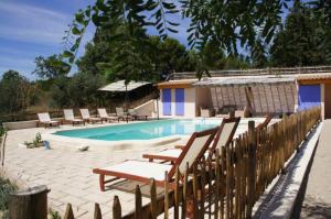 una piscina con sillas y una valla de madera en Olivier, en Mazan