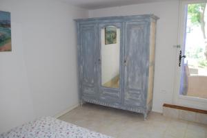 1 dormitorio con armario gris y espejo en Olivier, en Mazan