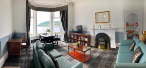 a living room with blue couches and a fireplace at St Ives Boutique Hotel in Dunoon