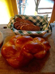 una pastelería en una tabla de cortar junto a una cesta de pan en B&B Mamma Mia, en Pisano