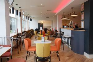 a restaurant with tables and chairs and a bar at Harben House in Milton Keynes