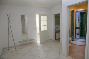 um quarto branco com um corredor com um espelho em Ferienwohnung Am Spechtbach em Wald-Michelbach