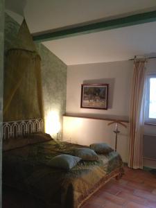 Un dormitorio con una cama con almohadas. en Les Jardins du Rebaut, en Béziers
