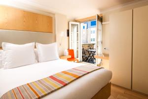 a hotel room with a bed and a balcony at Sydney House Chelsea in London