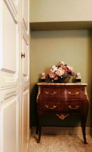 - une commode en bois avec un bol de fleurs dans l'établissement Casa Dellatorre, à Alba