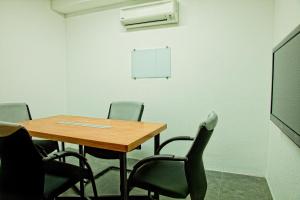 einen Konferenzraum mit einem Tisch, Stühlen und einem Whiteboard in der Unterkunft The Leverage Business Hotel - Rawang in Rawang