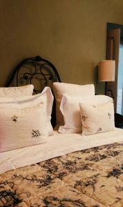 - un lit avec des draps et des oreillers blancs dans l'établissement Casa Dellatorre, à Alba