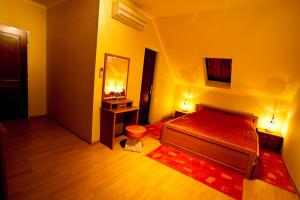 a bedroom with a bed and a vanity and a mirror at Villa Mikes Siófok in Siófok