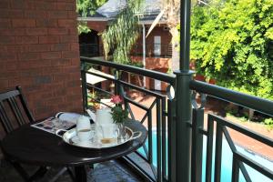 a table on a balcony with a cup of coffee at Premier Hotel Falstaff in Johannesburg