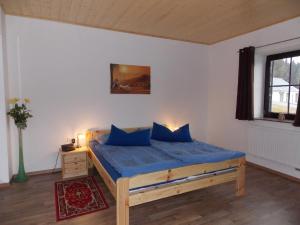 バイエリッシュ・アイゼンシュタインにあるFerienwohnung Wittenzellnerのベッドルーム1室(青いシーツと窓付)