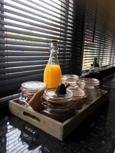 a bottle of orange juice sitting on a counter with jars at @ No.4 in Castle Cary